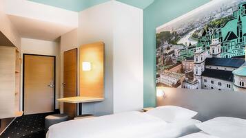 Ein Hotelzimmer mit einem Bett, einem Schreibtisch, einem Stuhl und einer Wandlampe.