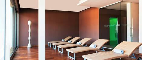 A modern relaxation area with wooden flooring, a unique sculptural piece, and a green door with a motivational quote.
