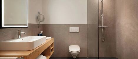 Une salle de bain moderne avec un lavabo, des toilettes et une douche à parois de verre.