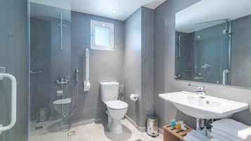 A modern bathroom with a glass shower enclosure, a toilet, a sink, and a mirror.