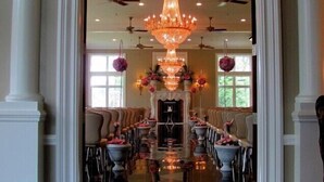 A grand hall with a central chandelier, rows of chairs, and ceiling fans. - Cameron Estate Inn & Restaurant (Mount Joy)