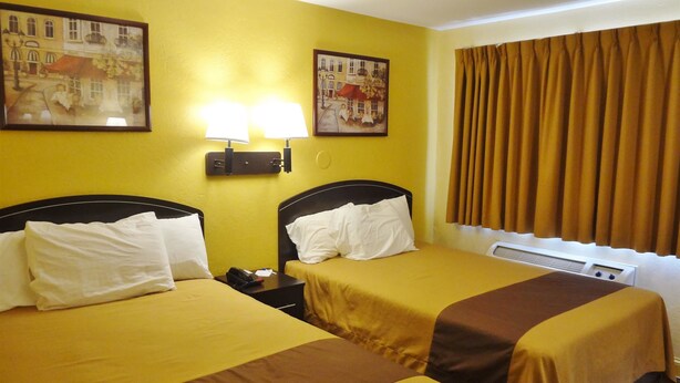 A hotel room with two beds, yellow walls, and two paintings. - Americas Best Value Inn Goldsboro (Goldsboro)
