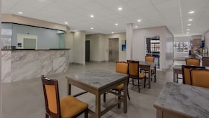 Un hall d’hôtel spacieux, doté d’un sol en marbre, de plusieurs espaces aménagés pour s’asseoir et d’un comptoir d’accueil.