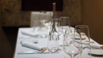 Una mesa dispuesta con cristalería transparente y platos, mostrando un ambiente de comedor formal.