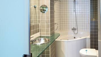 Un baño con lavamanos de vidrio, bañera y retrete.