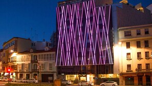 Un edificio moderno con una facciata unica caratterizzata da un motivo a zig-zag di luci.