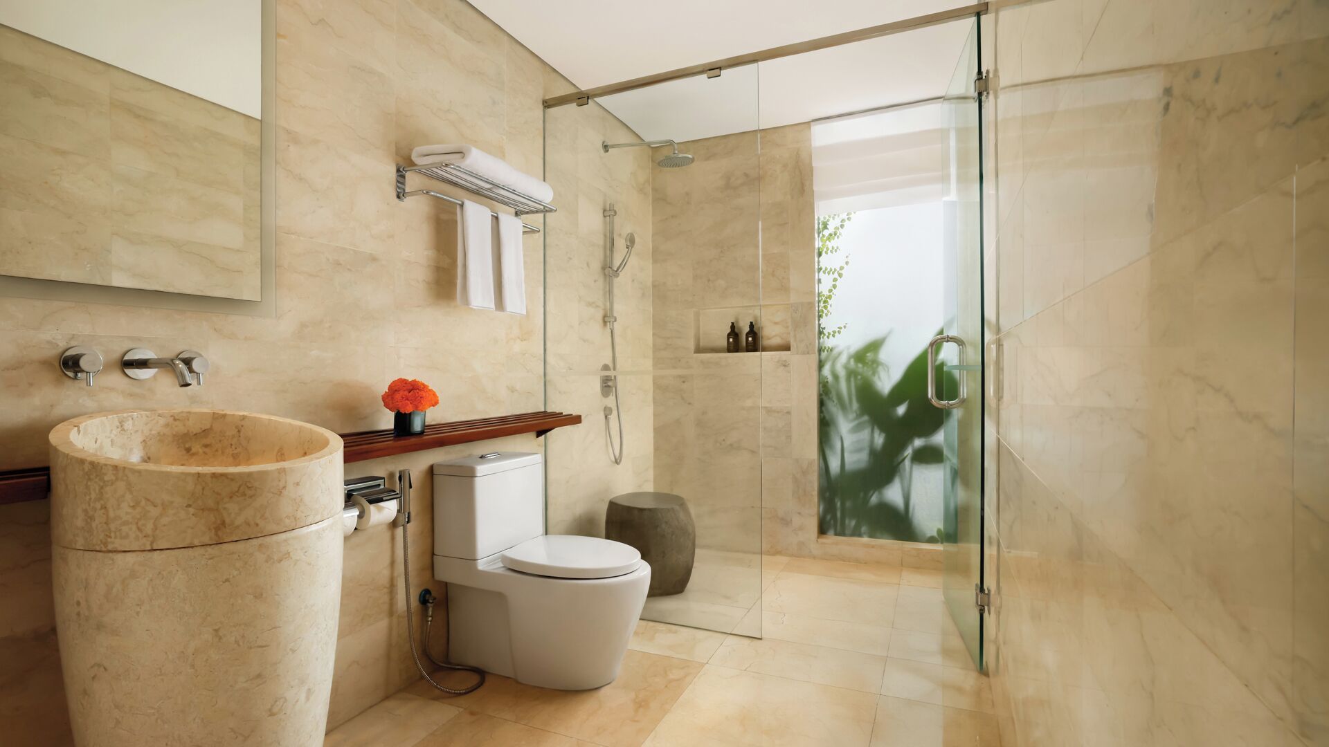 A modern bathroom with a marble sink, toilet, and shower.