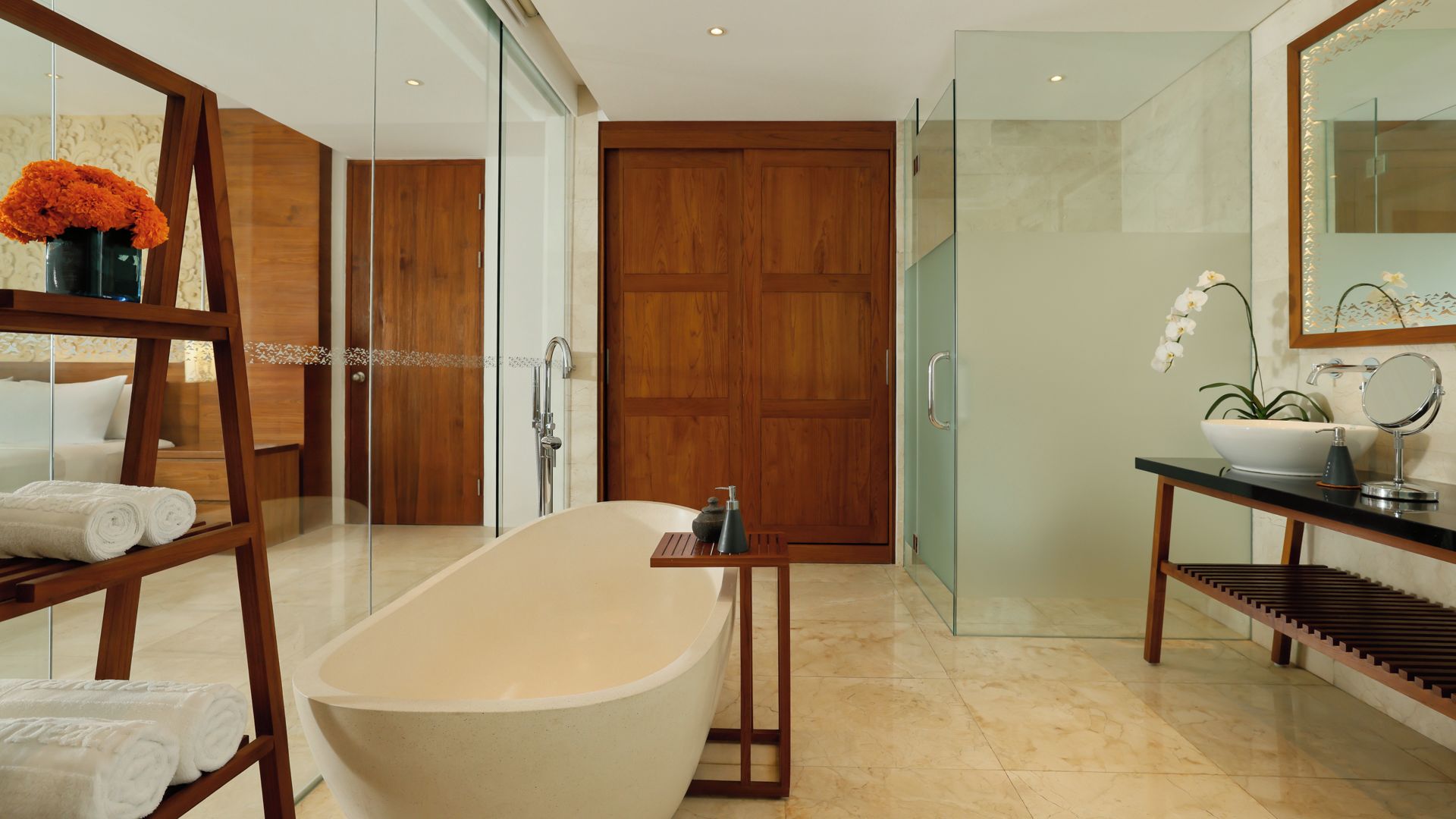 Un baño moderno con una bañera independiente, cabina de ducha con mampara de vidrio y tocador con lavamanos y espejo.