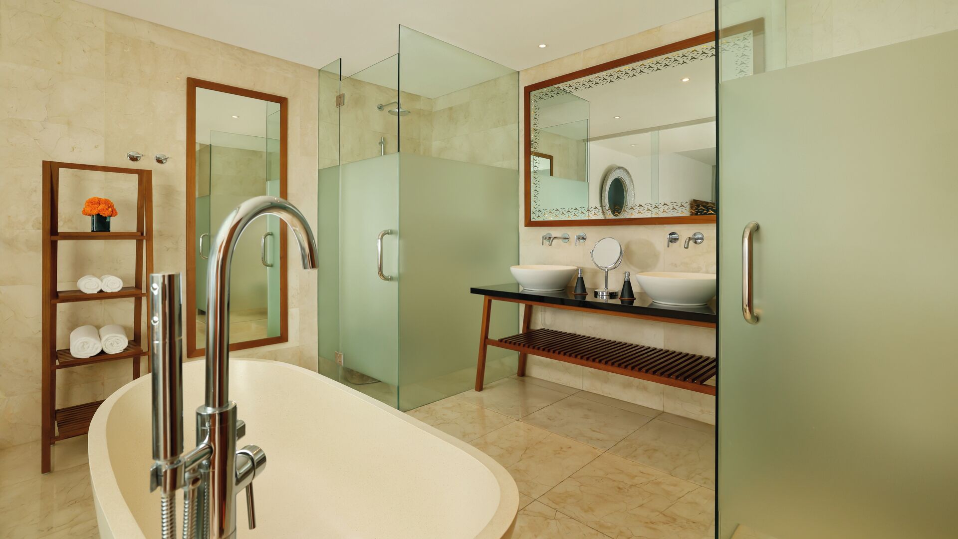 Un baño moderno con una bañera independiente, ducha con mampara de vidrio y tocador con un espejo grande.