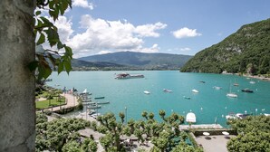 Una marina con barcos, un muelle y montañas al fondo.