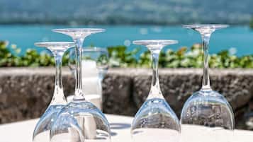 Mesa posta com copos de vinho, prato e talheres, com vista panorâmica.