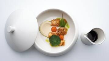 A white teapot and cup on a white surface.