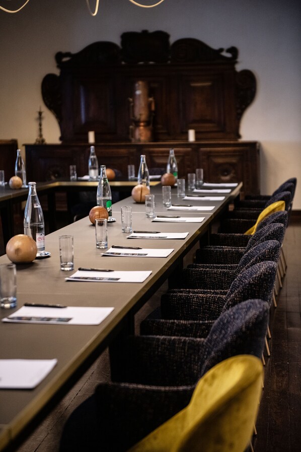 A conference room with a long table, chairs, and various items like bottles and glasses.