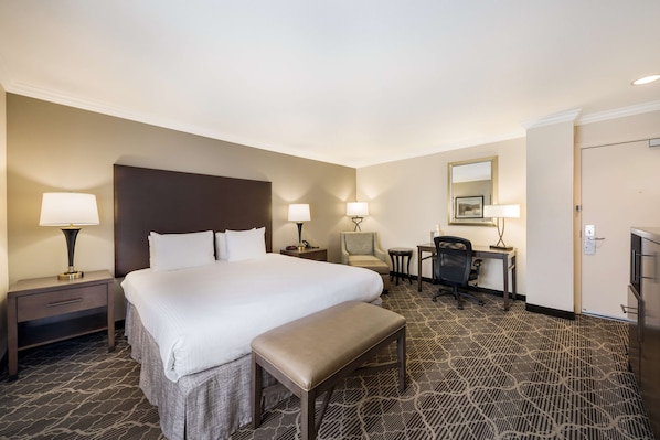 A hotel room with a large bed, a desk, a chair, a bench, and a television. - Best Western Danville Sycamore Inn (Danville)
