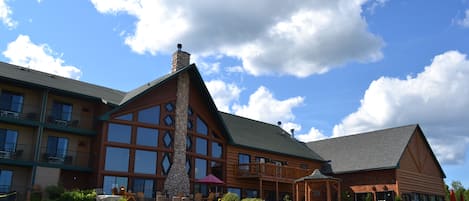 A large log cabin-style hotel with multiple balconies and a stone chimney.