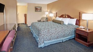 A hotel room with a large bed, bedside tables, a desk, and a chair. - Days Inn by Wyndham Marietta White Water (Marietta)