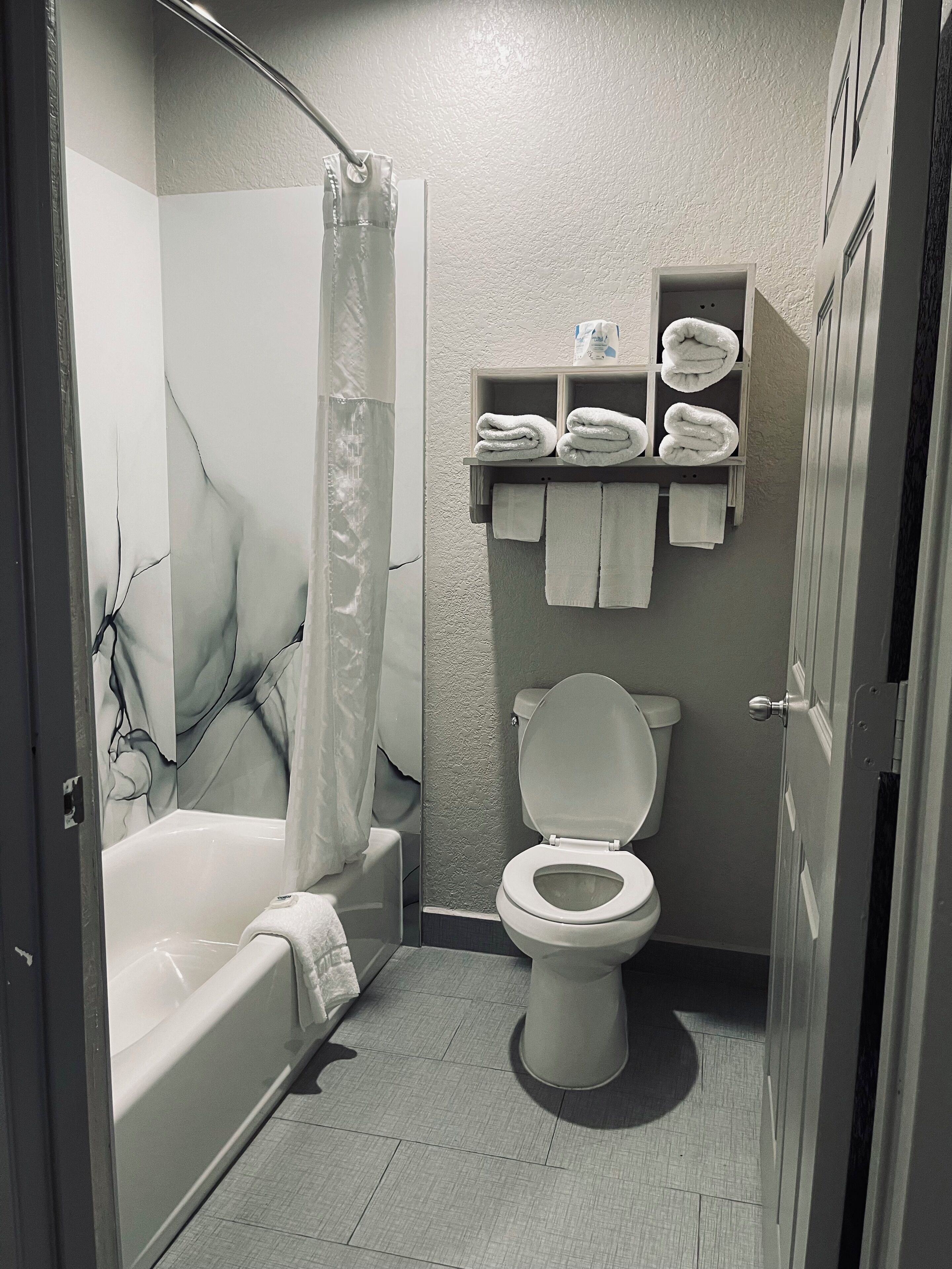 A bathroom with a bathtub, toilet, and a shower area.