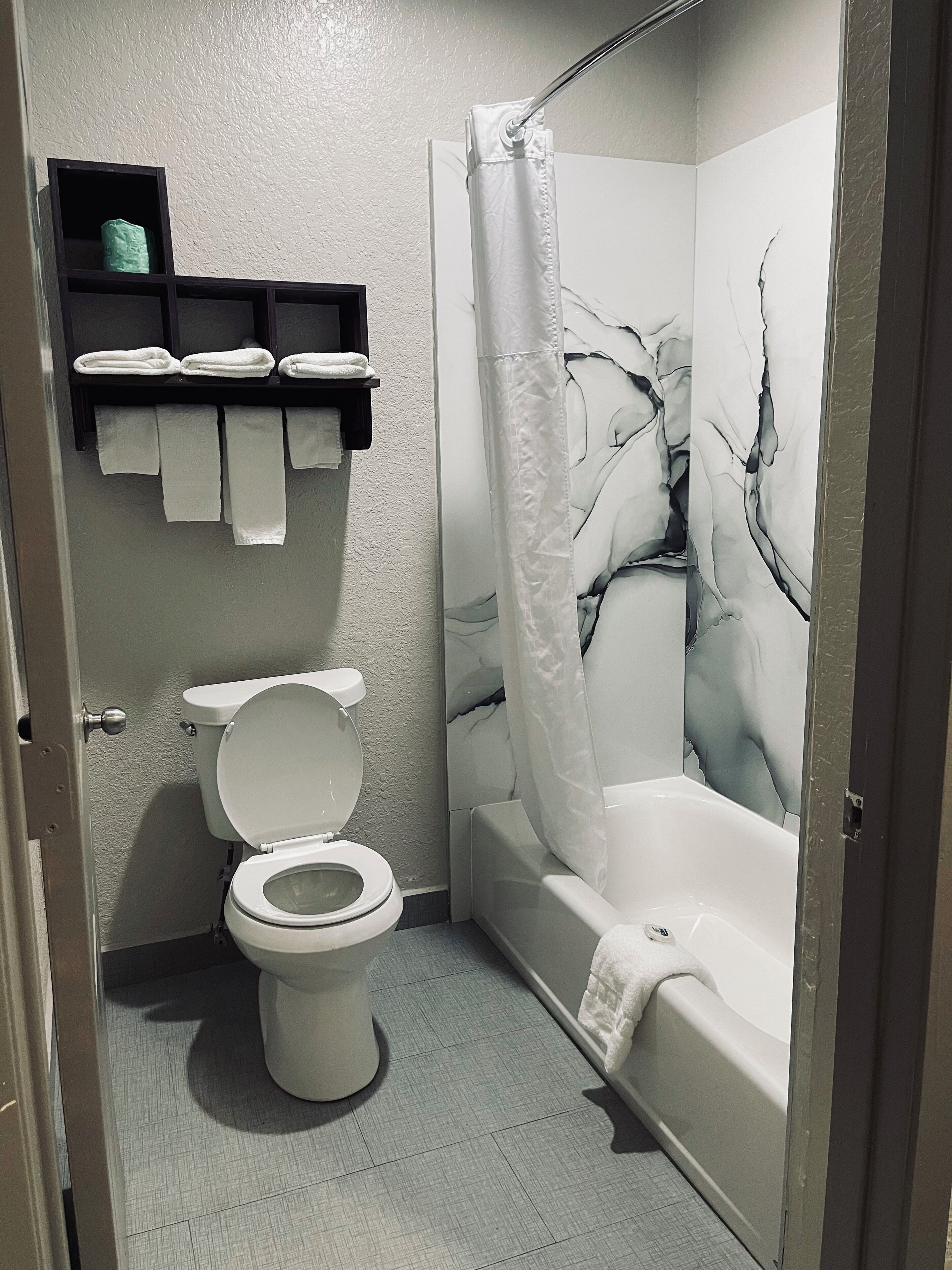Un bagno con il water, una vasca e una tenda da doccia.