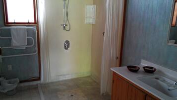 A bathroom with a shower, a sink, and a toilet.