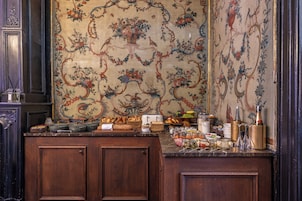 Una cocina con un detalle decorativo en la pared, muebles de madera y diversos alimentos sobre la encimera.