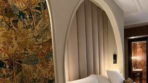 A bedroom with a large bed, a decorative headboard, and a mural on the wall. - Hotel Cour Saint Georges by CW Hotel Collection (Ghent)