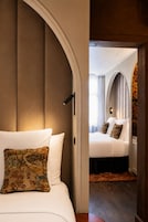 Habitación de hotel con una cama grande, un cojín decorativo, un arco y vistas del interior de la habitación.