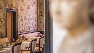 Un coin repas avec une table dressée pour quatre personnes, des chaises et un vase décoratif.