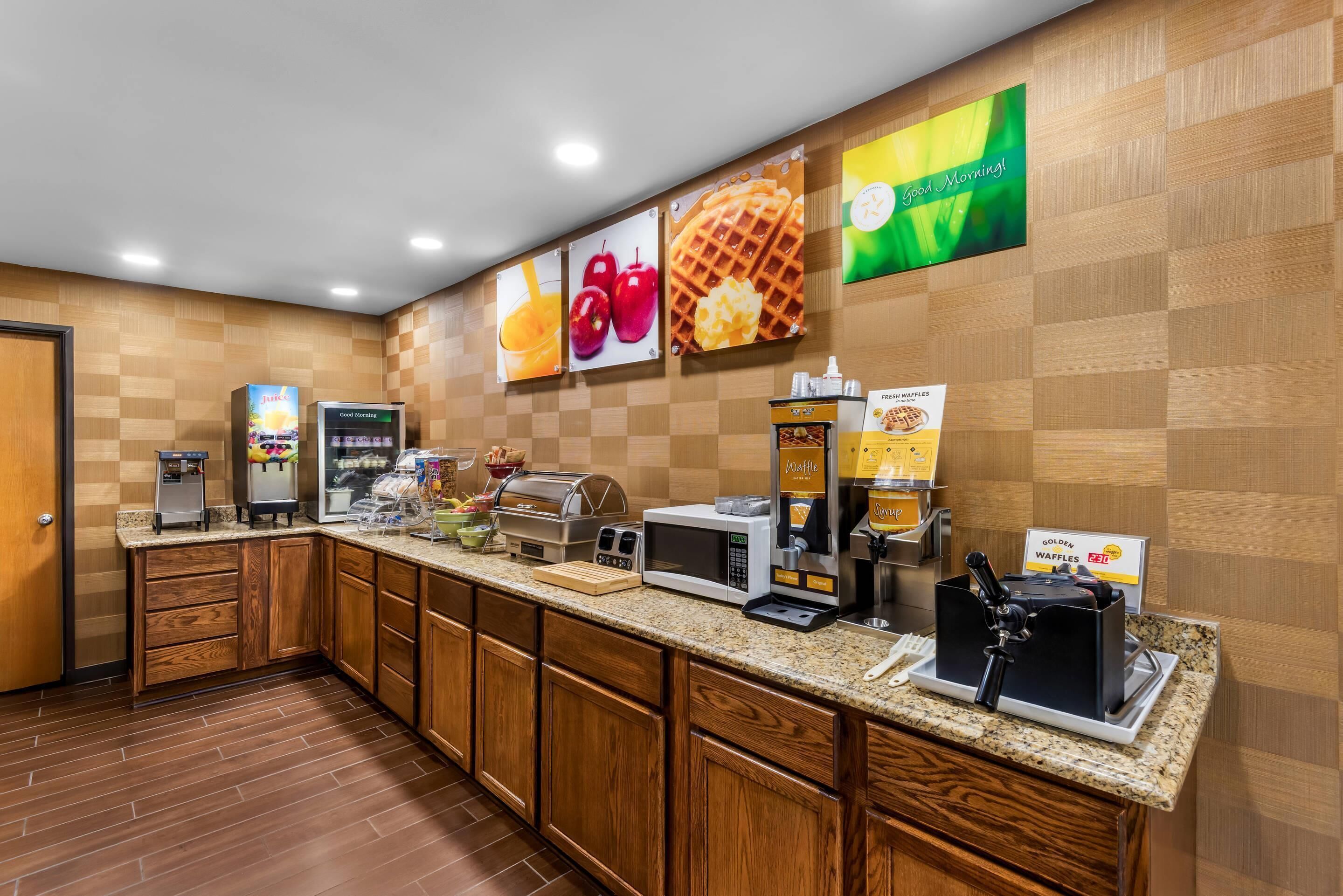 A breakfast bar with a coffee machine, waffle maker, and a sign for 'Golden Waffles.'