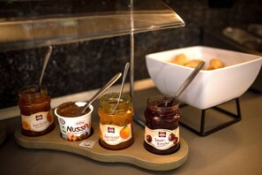 Three jars of jam on a wooden tray.