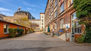 A street view with buildings, a clear sky, and a construction site in the background. - a&o Berlin Friedrichshain (Berlin)