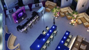 A spacious indoor area with high ceilings, multiple seating arrangements including sofas and tables, and a bar area with a counter.