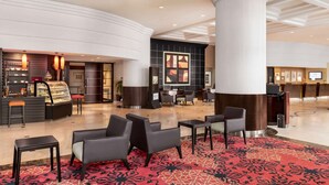 A spacious lobby with a central seating area, a reception desk, and a food display.