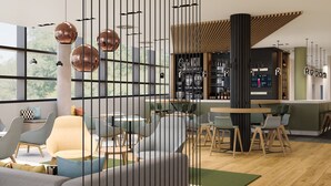 Un espace bar moderne, doté de sièges, d’un comptoir et offrant une vue à travers une cloison décorative.
