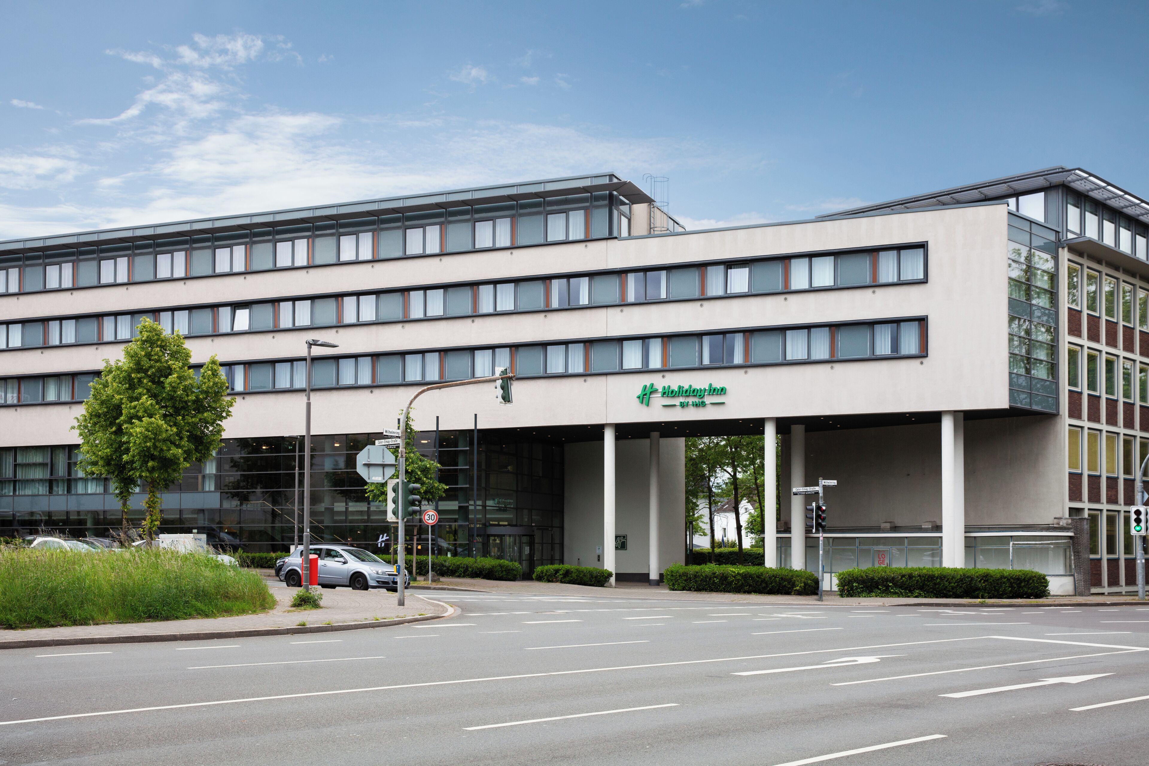 A modern building with a flat roof, large windows, and a sign for 'Holiday Inn Express.'