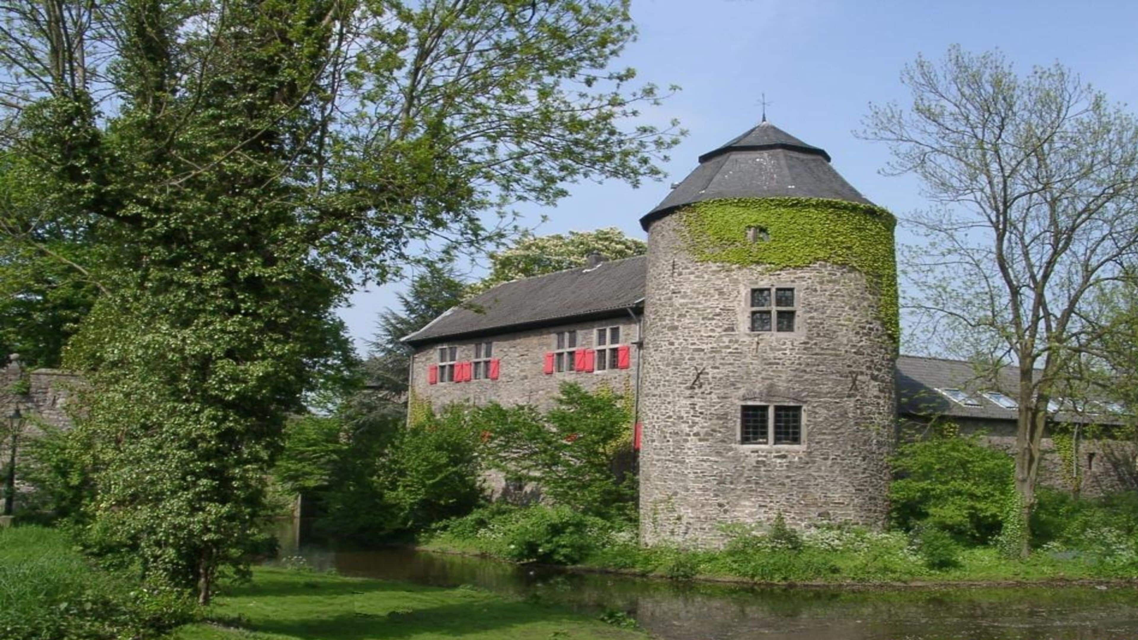 A stone tower with a conical roof, red shutters, and a small window.