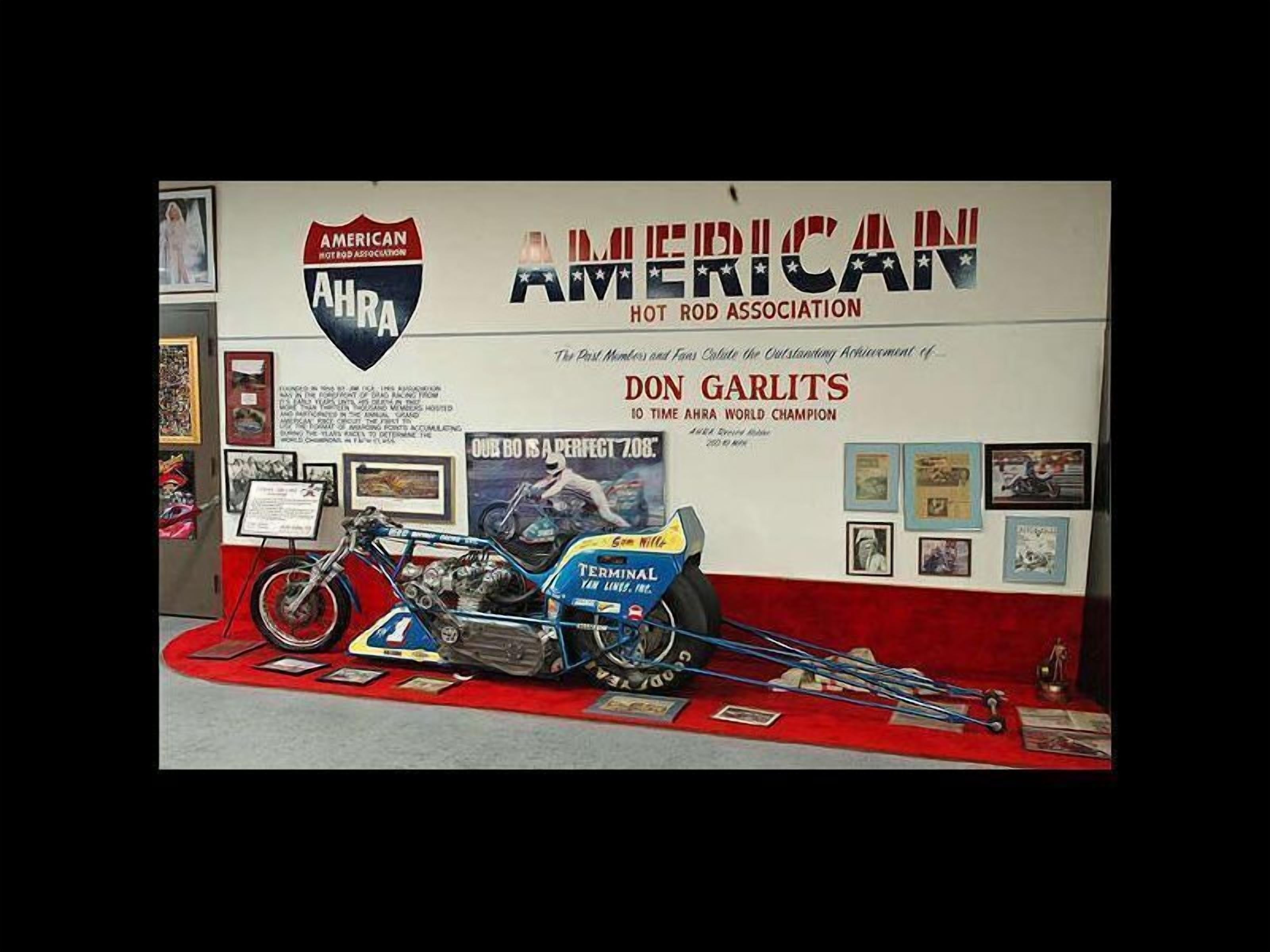 A display featuring a motorcycle and a sign for the American Hot Rod Association, highlighting Don Garlits as a world champion.