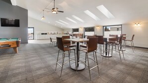 A spacious room with a pool table, a ceiling fan, and a dining area with chairs and a table. - Econo Lodge Williston (Williston)