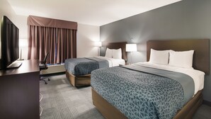 A hotel room with two beds, a desk with a computer, and a TV. - Econo Lodge Williston (Williston)