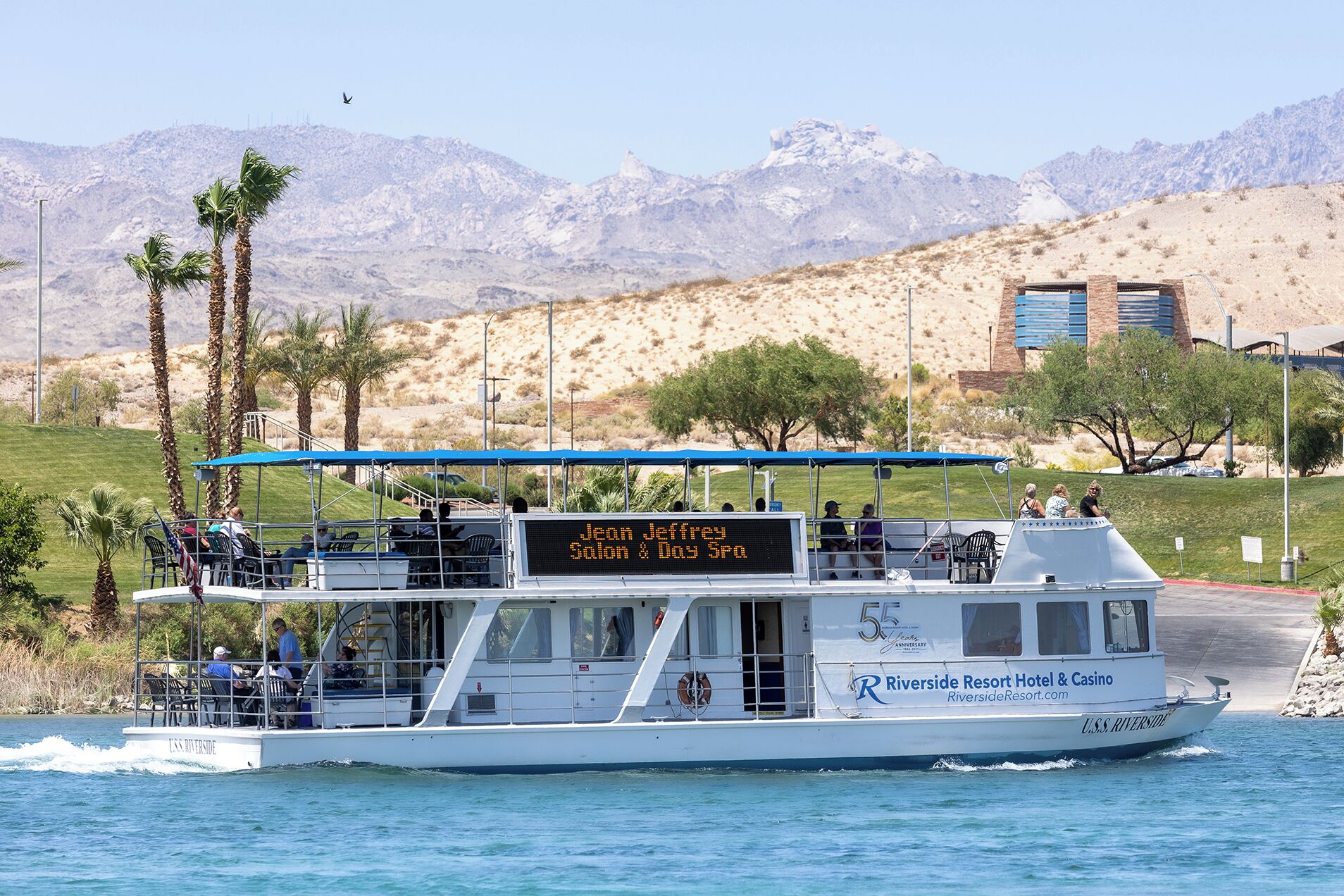 Un bateau arborant une enseigne numérique indiquant « Jeffrey Salon & Day Spa » et portant les couleurs de « Riverside Resort Hotel & Casino ».