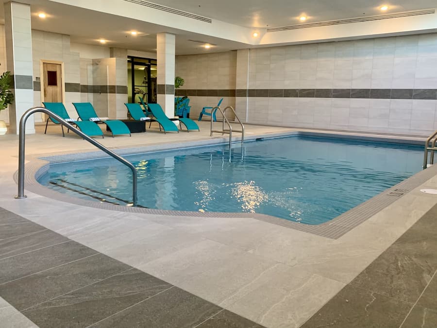 Piscine intérieure, piscine extérieure en saison, chaises longues