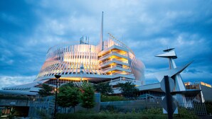 A modern building with a unique architectural design, featuring multiple balconies and a prominent vertical structure. - Hotel Universel Montreal (Montreal)