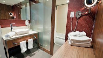 Une salle de bain moderne avec une douche à parois de verre, un meuble-lavabo avec un miroir et un porte-serviettes.