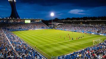 A stadium with a large seating capacity, a central field, and a distinctive tower structure.