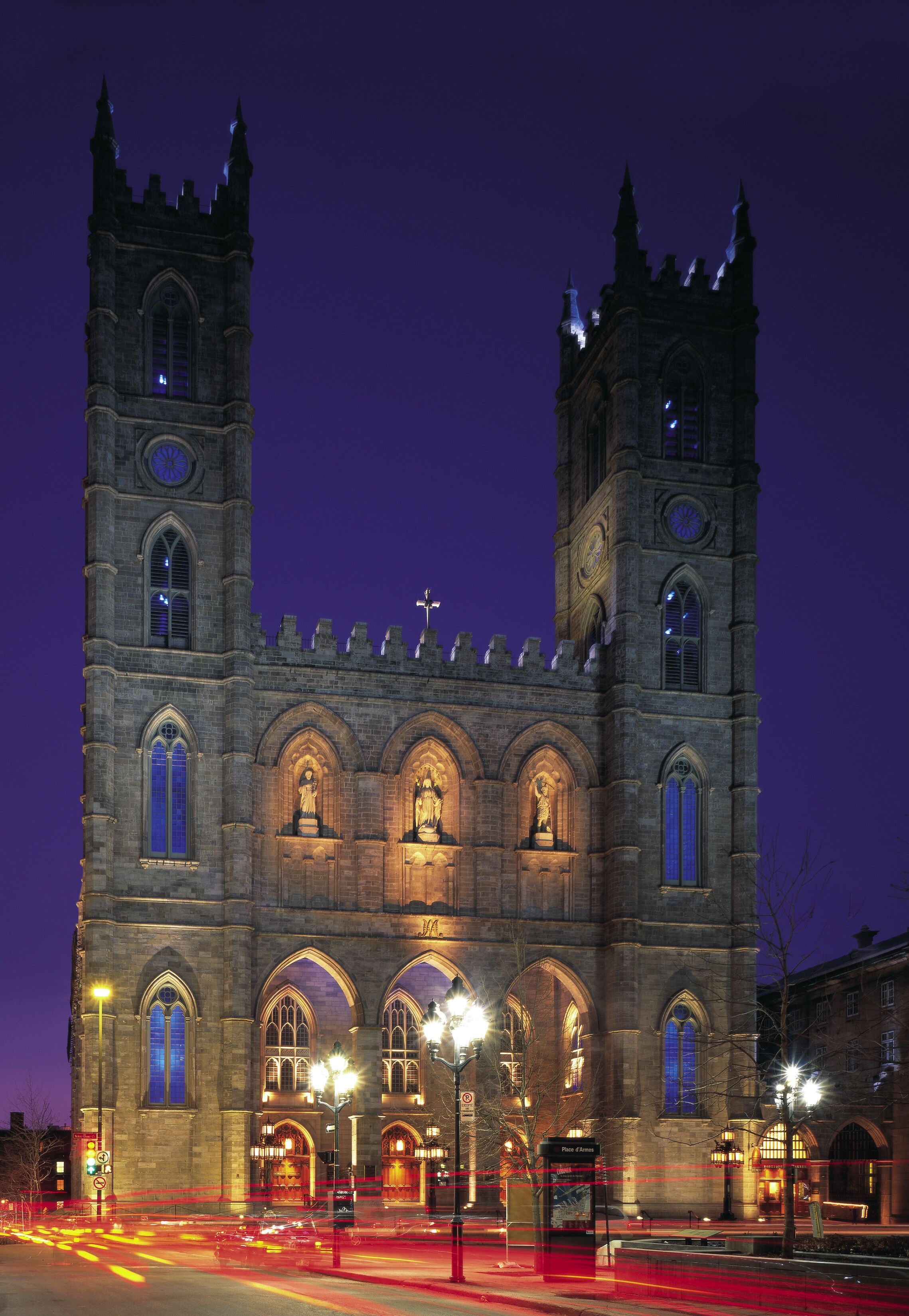 A historic building with two towers, arched windows, and a clock.