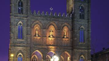 A historic building with two towers, arched windows, and a clock.