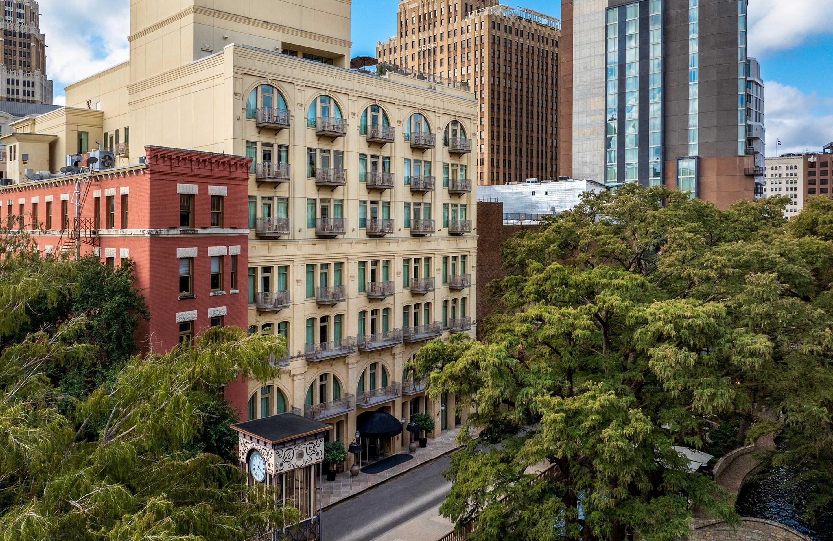 A multi-story hotel with a classic architectural style, featuring balconies and a central courtyard.
