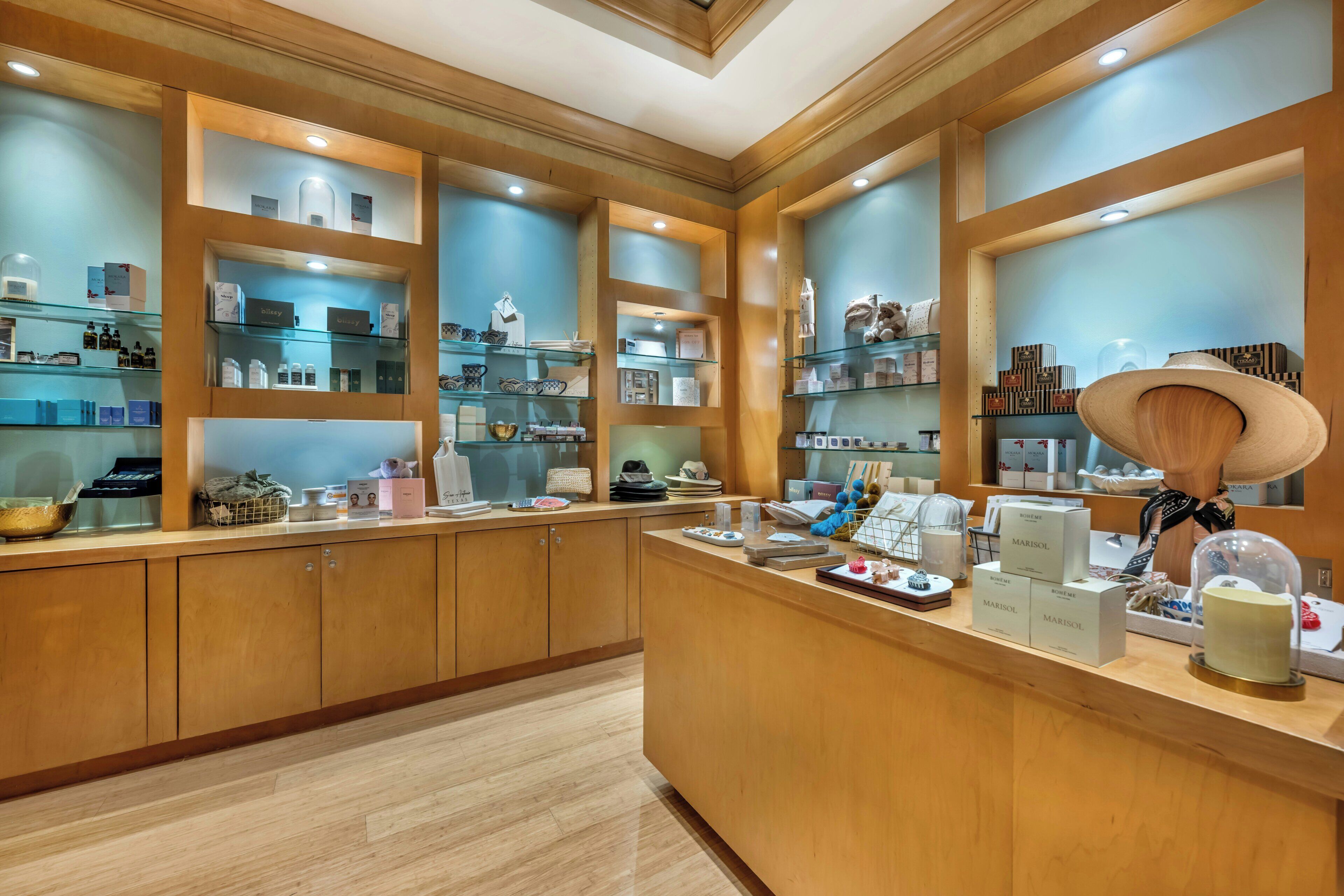 A well-lit, wooden-framed retail space with glass display shelves and a variety of products.
