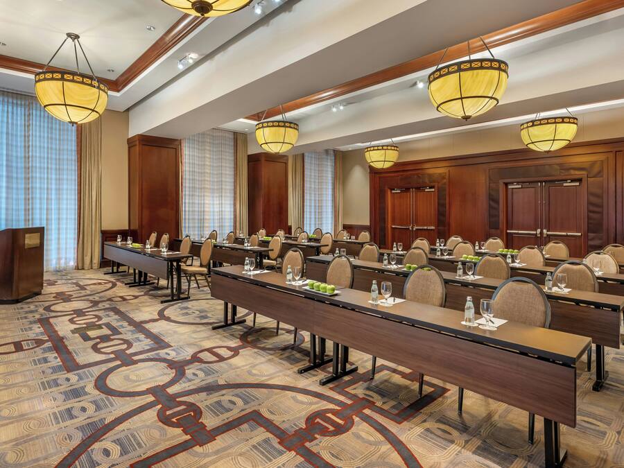 A conference room with long tables, chairs, and a podium.