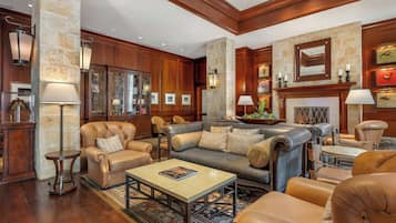 A spacious living room with leather sofas, a coffee table, and a fireplace.