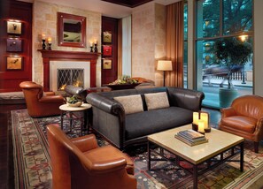 Relax in comfort with a fireplace, leather sofas, and armchairs, surrounded by a view of the outdoors.